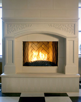The Palladian stone mantel has leaf and vine detail, and a beautiful arch.  Custom raised hearth shown