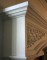 Delicate leaf details in the spandrel decorate this stone mantel